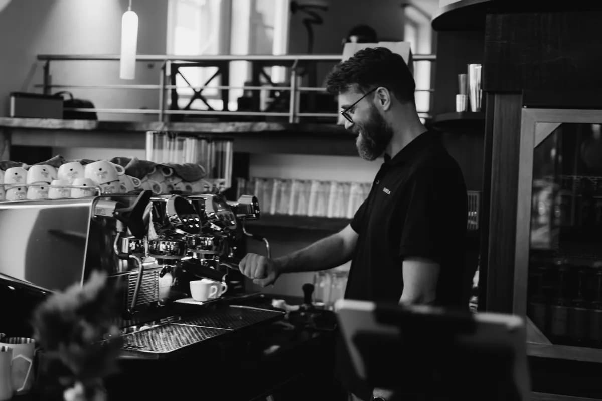 Barista an der Siebträgermaschine, schwarz-weiß