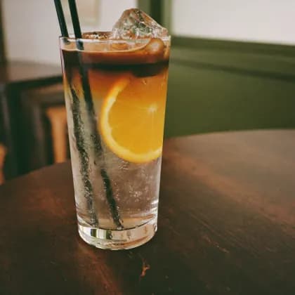 Espresso Tonic im hohen Glas mit Orangenscheibe