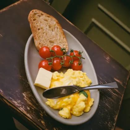 Rührei mit Brot und geschmorten Kirschtomaten